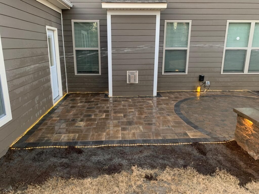 Durable stamped concrete patio with landscape lighting for outdoor entertaining.