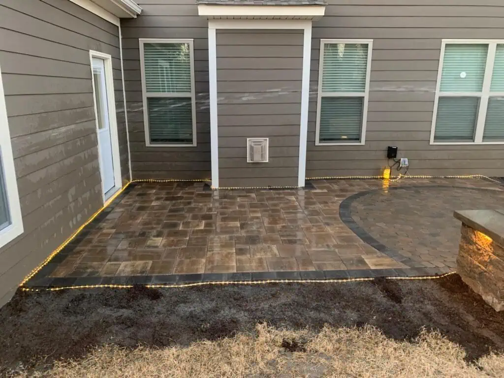 Durable stamped concrete patio with landscape lighting for outdoor entertaining.