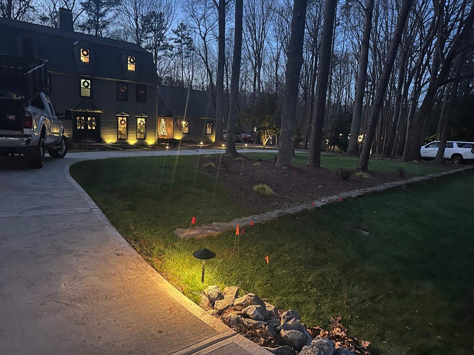 Landscape lighting highlights garden features and enhances outdoor ambiance at dusk.
