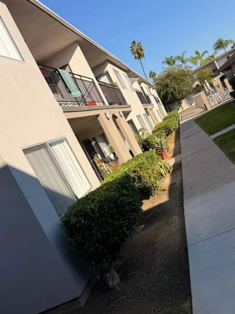 Beautiful apartment exterior with lush shrubbery and well-maintained landscaping.